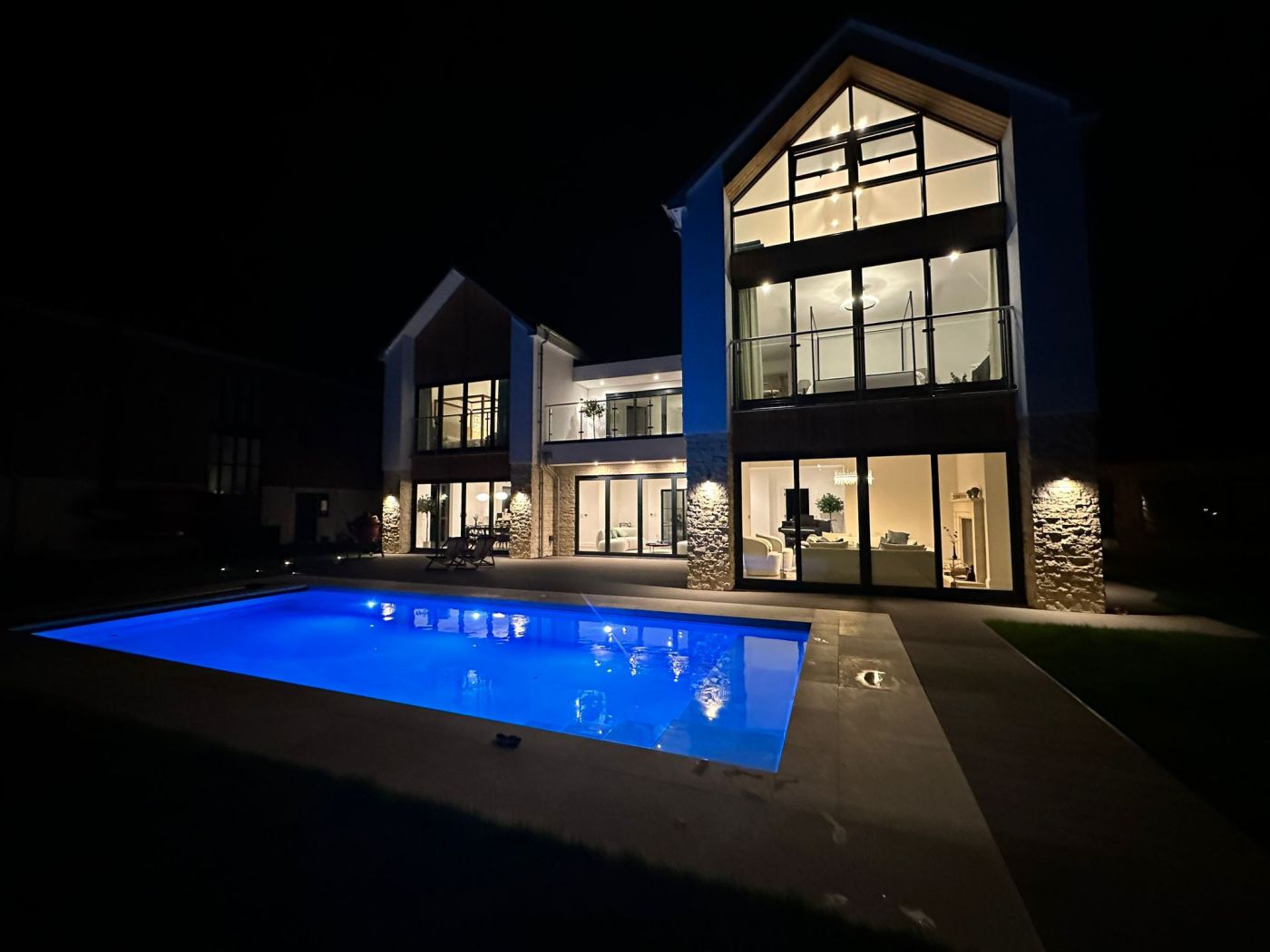 outdoor pool at night with led lights on and cover open